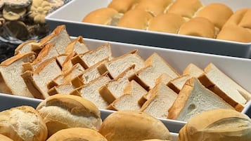 A buffet with various bread and pastries.