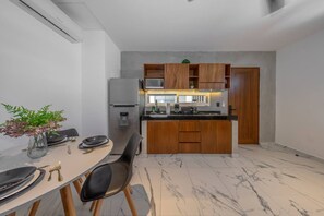 Een moderne keuken met een centraal eiland, houten kastjes en een ingebouwde magnetron.