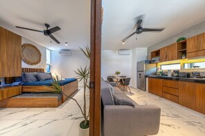Een modern appartement met een zithoek, een eethoek en een keuken.