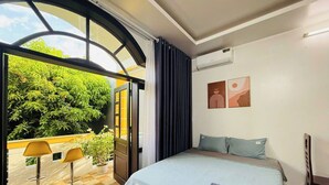 Una camera da letto con un letto, vista sul verde all'esterno e un pavimento a scacchi.