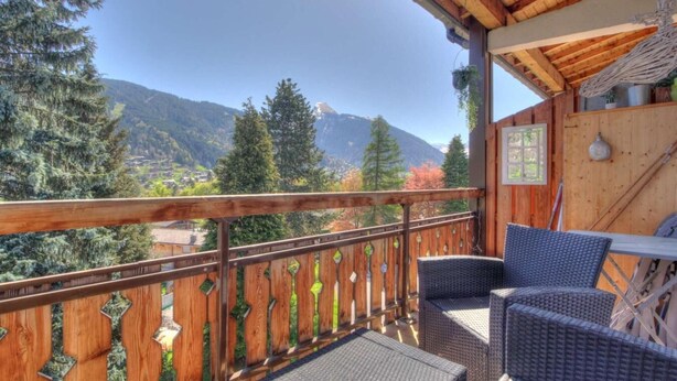 A wooden balcony with wicker furniture overlooking a mountainous landscape. - 3rd floor, balcony, parking, tv, ski locker, 35m², Morzine (Morzine)