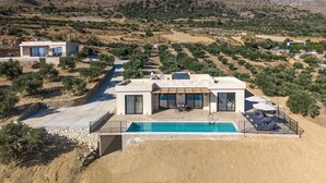 A modern villa with a swimming pool, surrounded by olive groves and mountains. - Filade Luxury Villa 2 (Agios Vasileios)