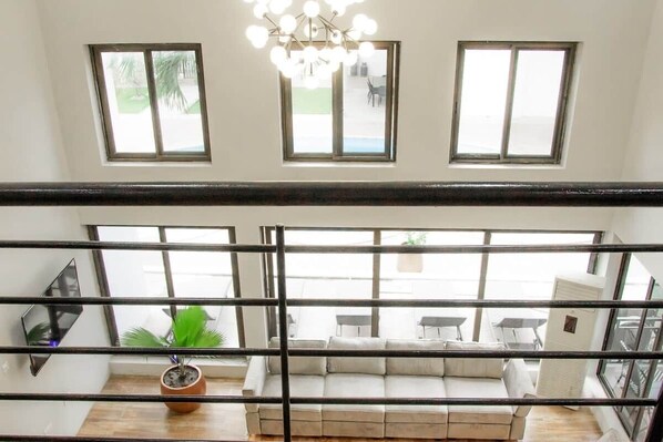 Una habitación con un ventanal amplio, un sofá y una planta en maceta.