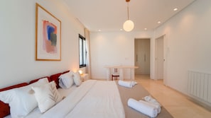 Une chambre d’hôtel moderne avec un grand lit, un bureau et une vue sur le couloir.