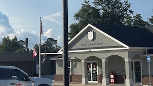 A Welcome Inn sign with an American flag, a Salvation Army building in the background, and a clear sky. - Newly remodeled 14-room hotel in charming St. Mary's . (St. Marys)