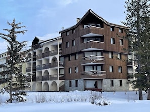 A multi-story hotel with balconies and a stone facade.