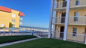 A hotel with a pool, a grassy area, and a view of the ocean. - Ground Floor Ocean View 2/2 (New Smyrna Beach)