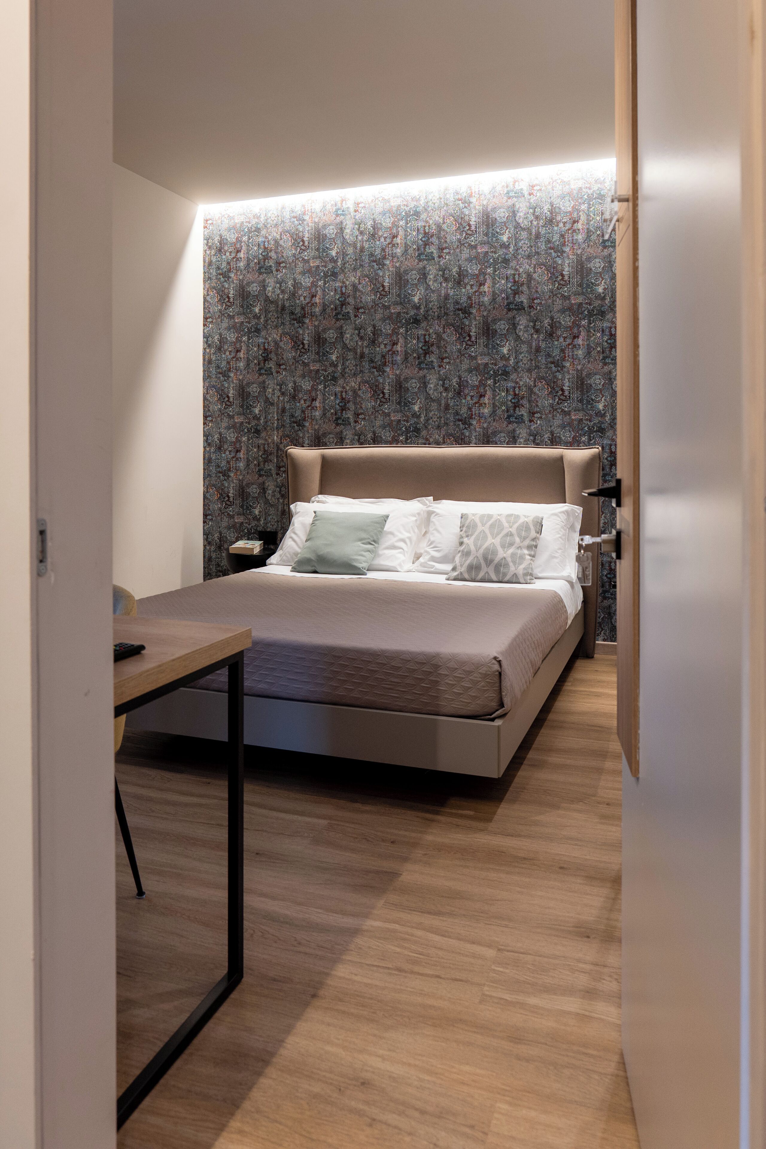 Un dormitorio moderno con cama, mesita de noche y velador.