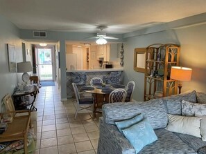 A compact living space with a dining area, kitchenette, and a sofa.