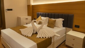 A hotel room with a bed, two nightstands, and a wall-mounted control panel. - Parth Hotel (Ayodhya)