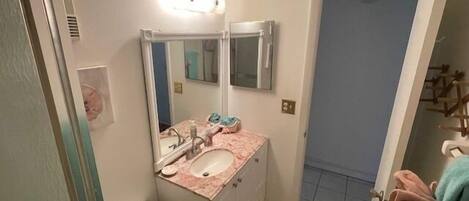 Un baño con lavamanos, espejo e inodoro.
