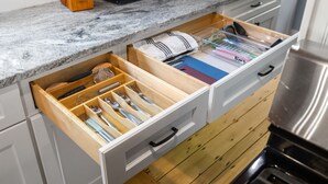 Cocina con un organizador de cajones que contiene utensilios y un microondas.