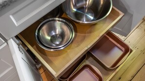 Una encimera de cocina con cuencos de acero inoxidable y bandejas marrones.