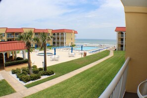 A hotel with a pool area, palm trees, and a view of the beach. - Welcome to the Beach! (New Smyrna Beach)