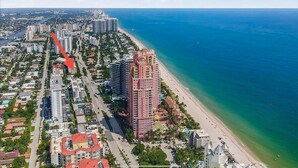 Un paysage urbain côtier avec un grand hôtel, qui se distingue par sa hauteur, situé à proximité d’une plage.