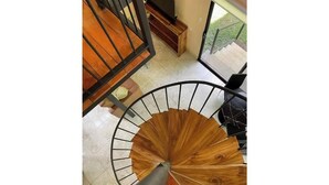 Un escalier en colimaçon avec des marches en bois et une rampe en métal.