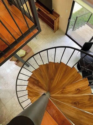 A spiral staircase with a wooden finish and metal railings.