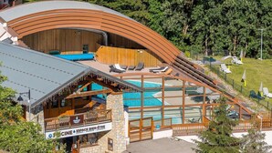 Un resort con piscina, sillas de descanso y terraza de madera.