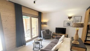 Una sala de estar moderna con un sofá, un televisor y una lámpara.