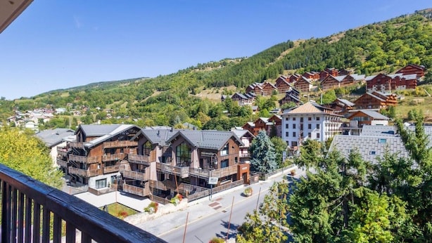 A mountain resort with wooden cabins and modern buildings, featuring balconies and a clear view of the surrounding hills. - 140m from ski slopes, 3rd floor, balcony, tv, 41m², Valloire (Valloire)