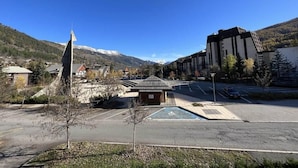 A parking lot with a handicapped parking space, a small building, and a mountain in the background.
