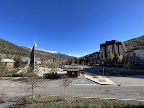 A parking lot with a handicapped parking space, a small building, and a mountain in the background.
