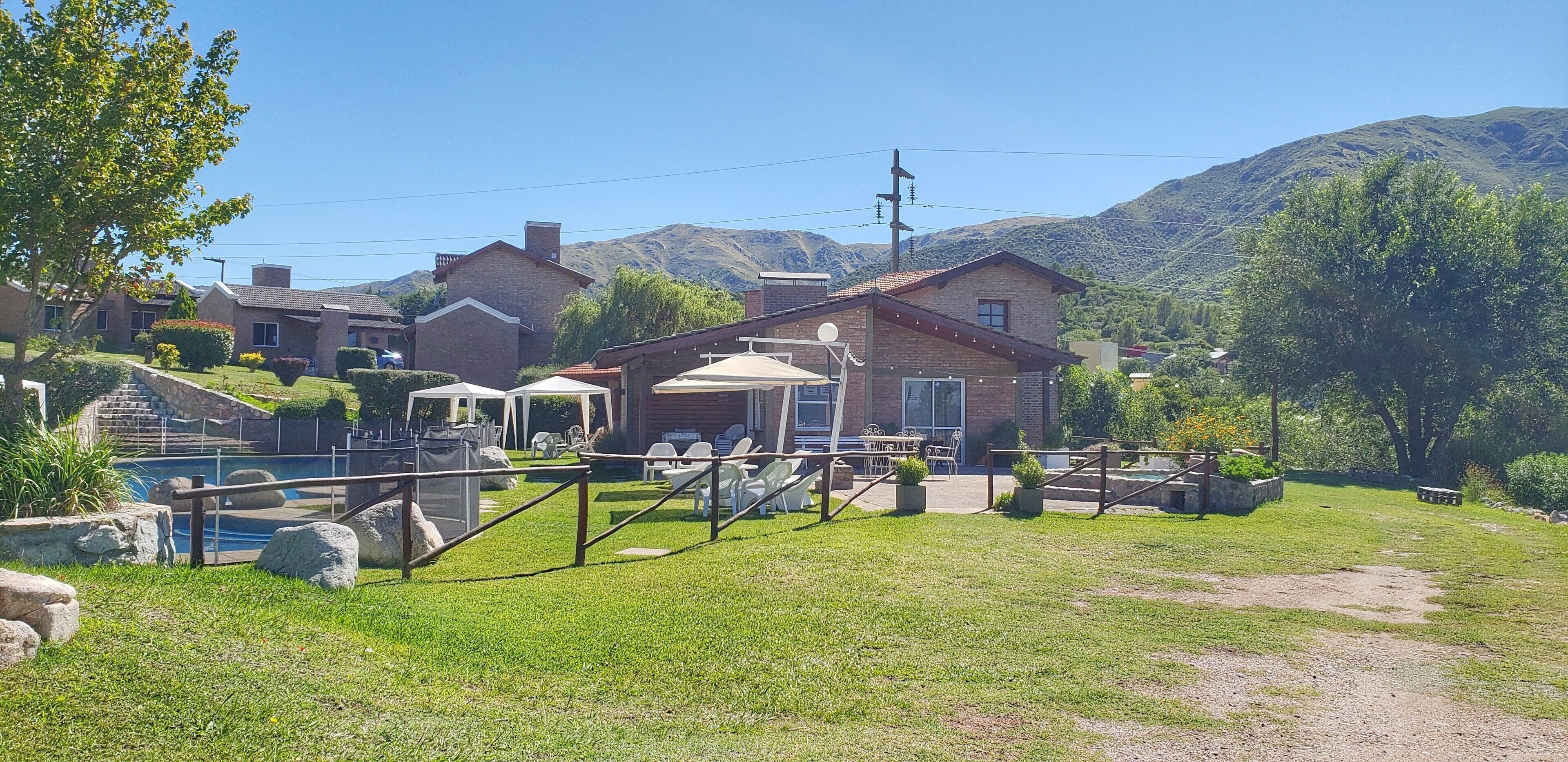 A residential area with houses, a swimming pool, and a mountain backdrop.