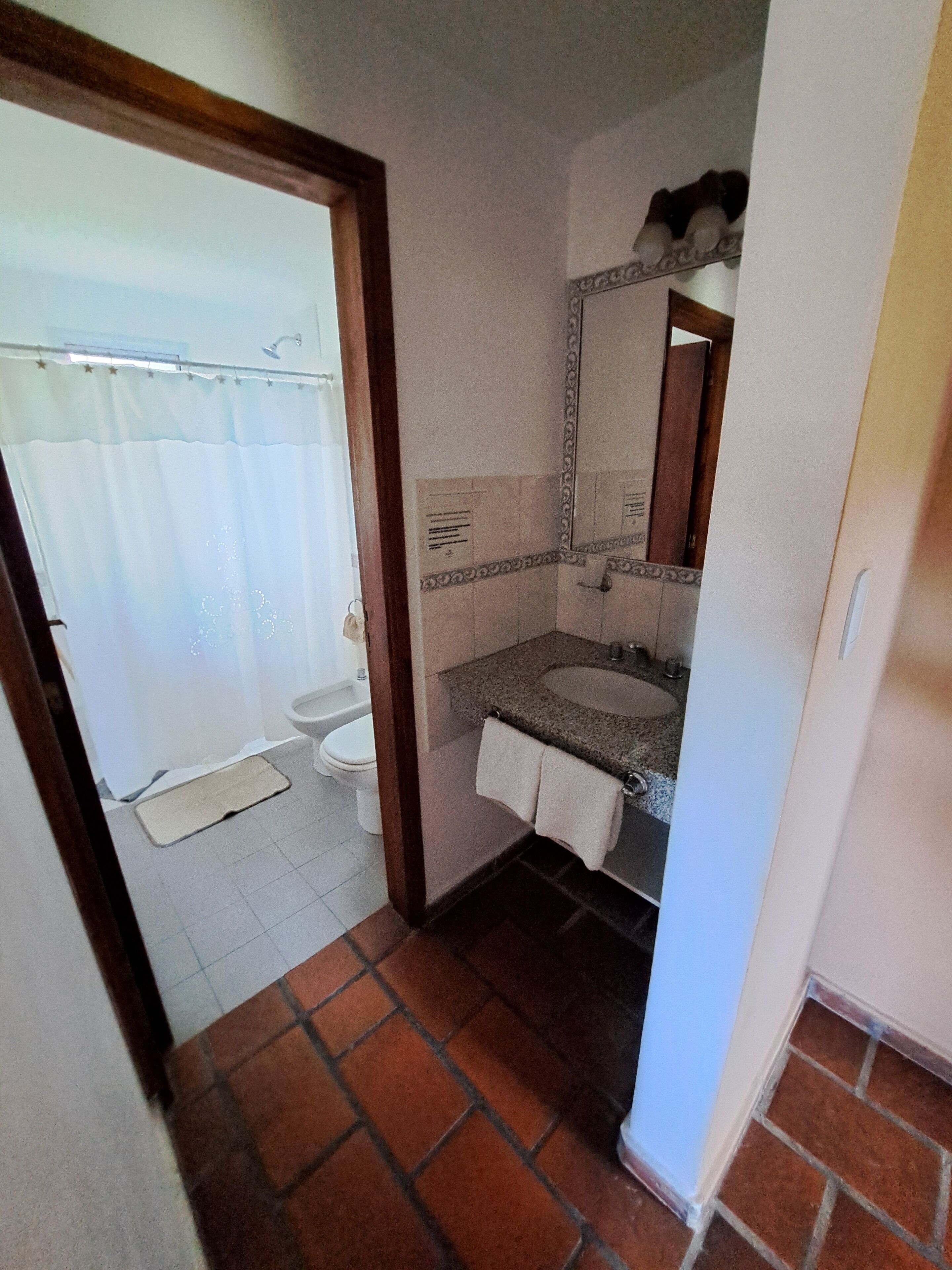A bathroom with a shower, toilet, and sink.