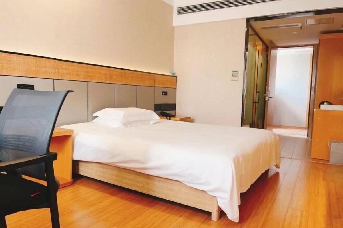 Ein Hotelzimmer mit Bett, Schreibtisch und Stuhl.