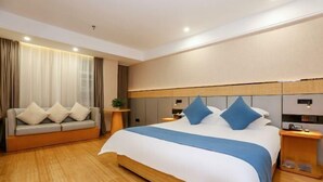 A modern hotel room with a large bed, a sofa, and a small table. - HUAZHU-StarwayHotel (Shangrao Central Plaza Pedestrian Street store) (Shangrao)