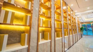 A modern hotel lobby with marble columns and illuminated shelves. - HUAZHU-StarwayHotel (Shangrao Central Plaza Pedestrian Street store) (Shangrao)