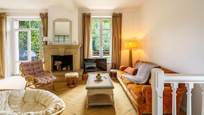 Una sala de estar acogedora con chimenea, sofá, sillón y televisión.