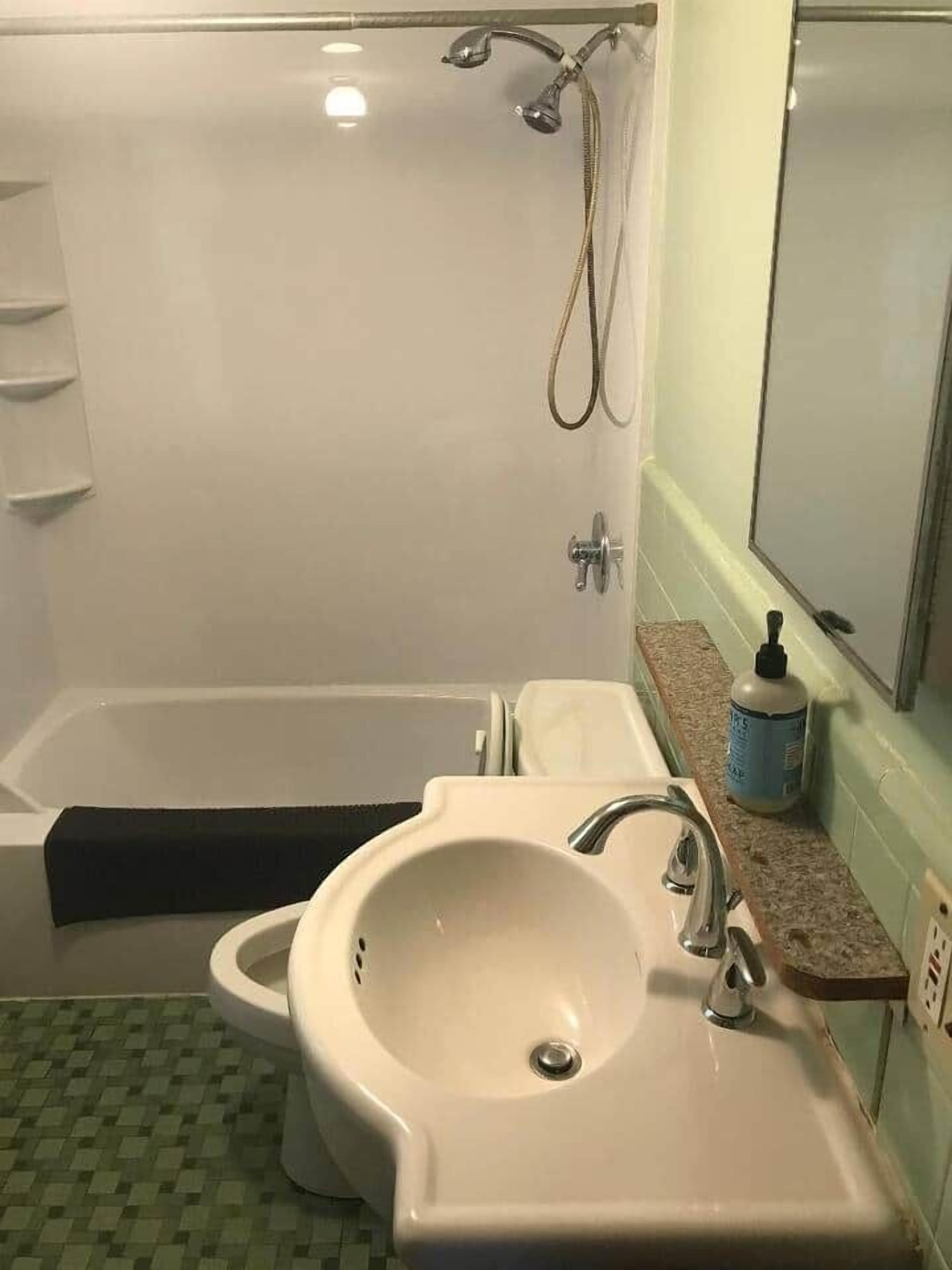 Un baño con bañera, lavamanos e inodoro.