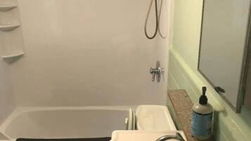 Un baño con bañera, lavamanos e inodoro.