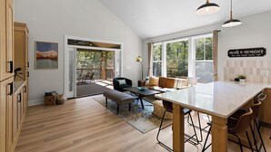 A spacious kitchen with a large island, wooden cabinets, and a view of the outdoors.