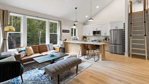 A modern kitchen with white cabinets, a stainless steel refrigerator, and a central island.