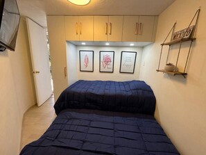 A bedroom with a bed, a wardrobe, and a shelf with a sign. - Acogedor apartamento tipo boutique cerca d Reforma (Mexico City)