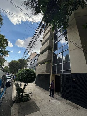 Een gebouw met meerdere verdiepingen, grote ramen en balkons.