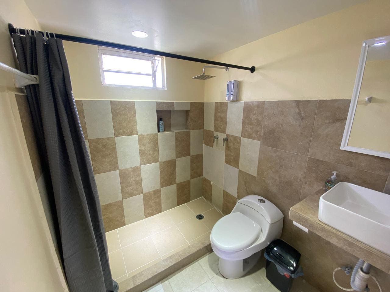 Un baño con ducha, inodoro y lavamanos.