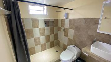 Un baño con ducha, inodoro y lavamanos.