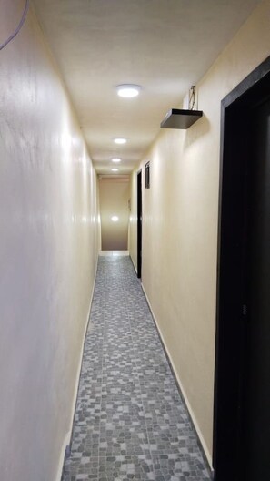 A narrow hallway with tiled flooring and beige walls. - Mini Hotel Chetumal – Habitación 4 · Cama King (Chetumal)