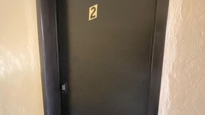 En dør med skilt med nummer 2, der angiver værelsesnummer 2.