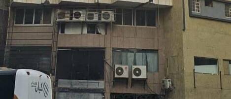 Un immeuble à plusieurs étages dont la façade est ornée de nombreuses unités de climatisation.