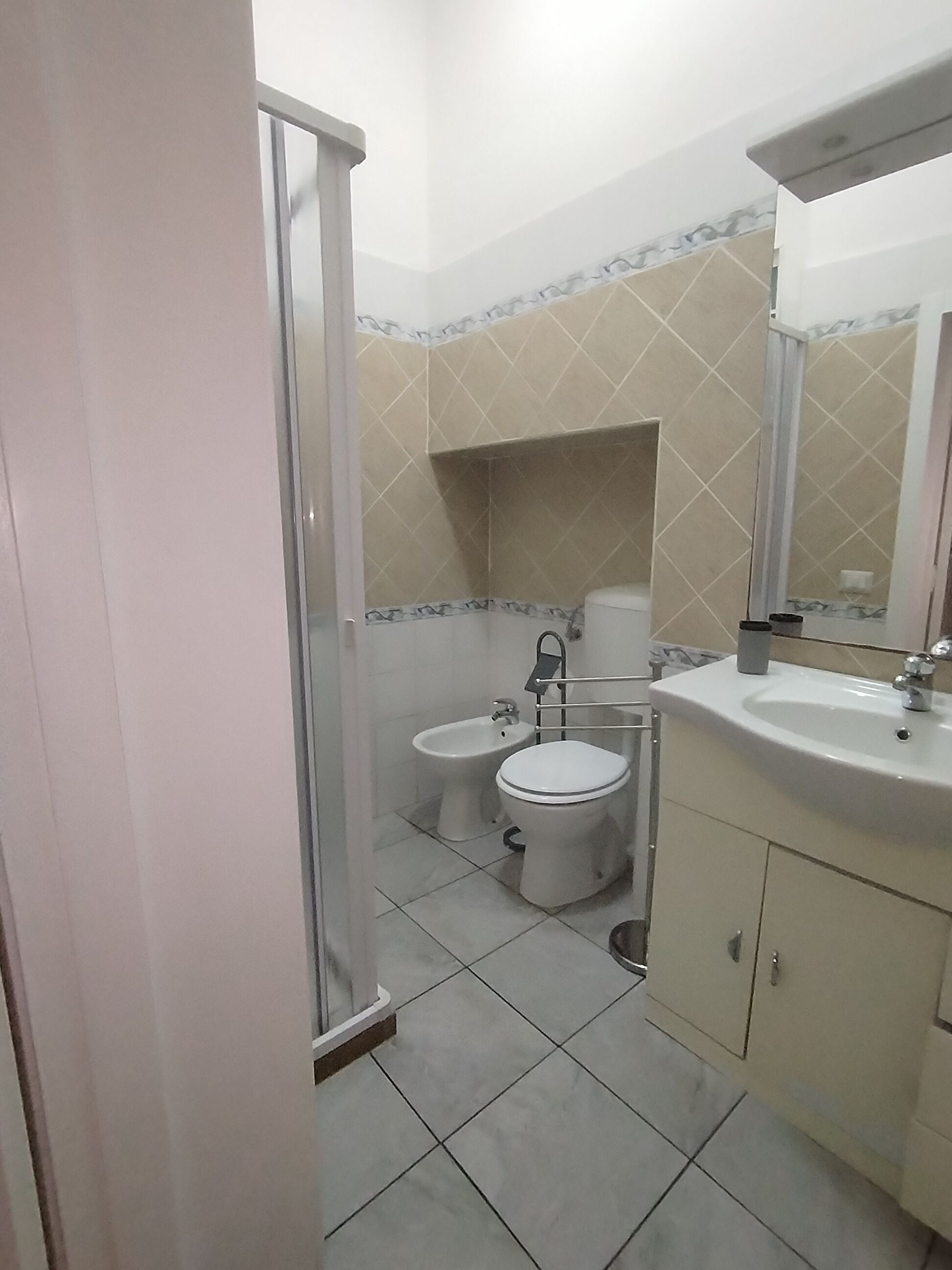 Une salle de bain équipée d’une douche, de toilettes, d’un bidet et d’un lavabo.