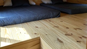 Eine Holzhütte mit zwei Betten und geneigter Decke.