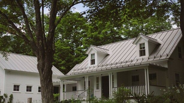 A white colonial-style house with a gabled roof and a covered porch. - Warren Village home steps from bubbling brook (Warren)