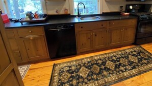 A kitchen with wooden cabinets, a dishwasher, a sink, and a microwave. - Warren Village home steps from bubbling brook (Warren)