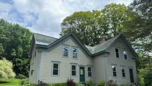 Une maison à deux étages, dotée d’un toit à pignon, d’un porche à l’avant et d’une pelouse bien entretenue.