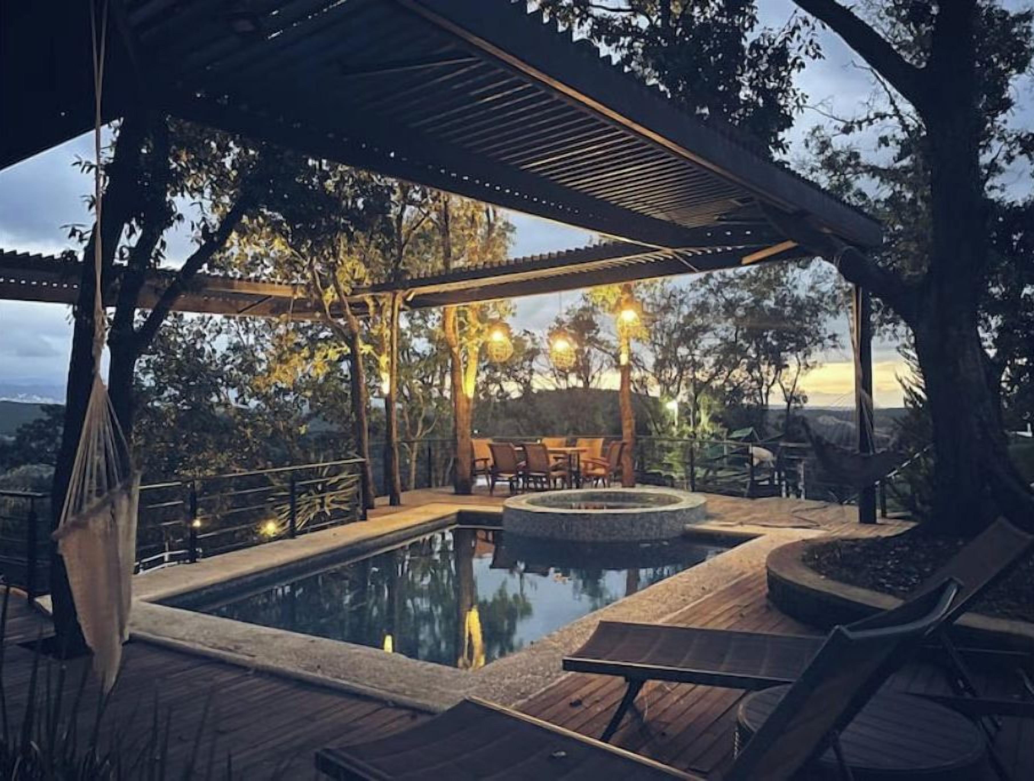 Un espace piscine agrémenté d’une pergola, de chaises longues et d’un jacuzzi.