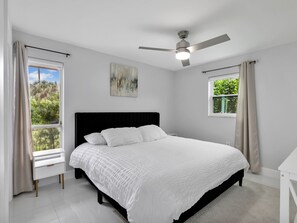 A bedroom with a bed, a ceiling fan, and two windows with curtains. - 1.5 miles 5 min 🚗 to beaches, King Beds, BBQ, Nintendo Switch 🎮, Pet friendly 🐶. (Naples)